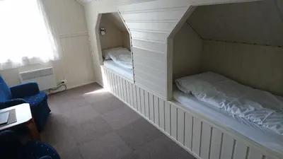 a small room with a bunk bed and a chair at Lunde Turiststasjon in Skei