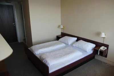 a bedroom with a bed with two pillows and a phone at Midtnes Hotel in Balestrand