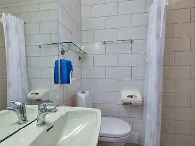 a white bathroom with a toilet and a sink at Gomobu Fjellstue in Ron