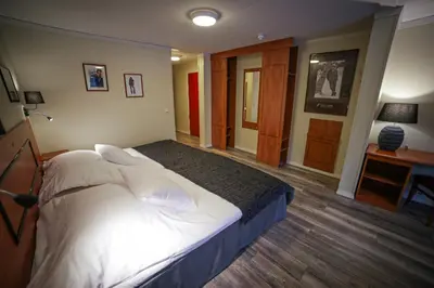 a bedroom with a large bed with white sheets and pillows at Vesterland Feriepark Hytter, hotell og leikeland in Sogndal
