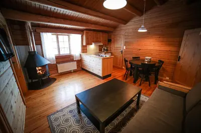 a kitchen and dining room with a table and a stove at Vesterland Feriepark Hytter, hotell og leikeland in Sogndal