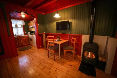 a living room with a table and a stove at Vesterland Feriepark Hytter, hotell og leikeland in Sogndal