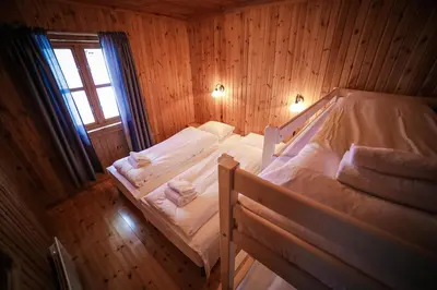 two bunk beds in a wooden room with a window at Vesterland Feriepark Hytter, hotell og leikeland in Sogndal