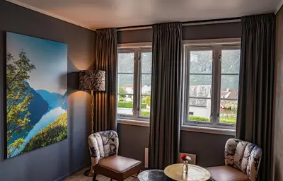 a room with two chairs and a table and windows at Hotel Aurlandsfjord in Aurland