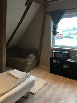 a bedroom with a bed and a large window at Bakkevik Brygge in Kalvåg