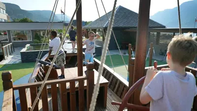 a group of children playing on a playground at Bremanger Fjord Hotell in Svelgen