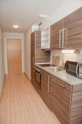 a kitchen with wooden cabinets and a sink and a microwave at Åkrafjordtunet Apartments in Teigland