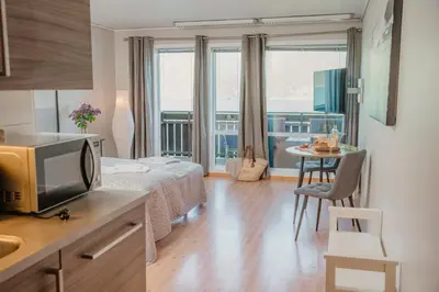 a room with a bed and a television and a table at Åkrafjordtunet Apartments in Teigland