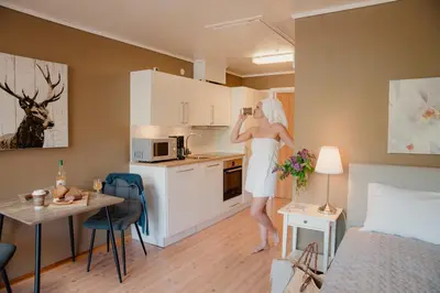 a woman in a white dress is standing in a kitchen at Åkrafjordtunet Apartments in Teigland