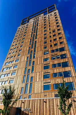 a tall building with a blue sky in the background at Wood Hotel by Frich's in Brumunddalen