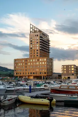 a group of boats in a marina with a tall building at Wood Hotel by Frich's in Brumunddalen