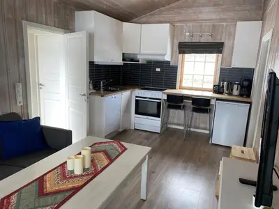 a kitchen with white cabinets and a table in a room at Sandviken Camping in Austbygdi