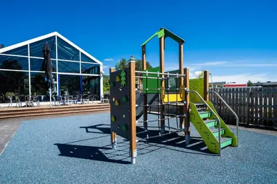 a playground with a slide in front of a building at Frich's Hotell og Spiseri Alvdal in Alvdal