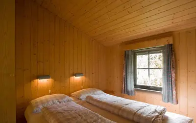 a bedroom with two beds in a room with a window at Jølsterlia Hyttetun in Årdal