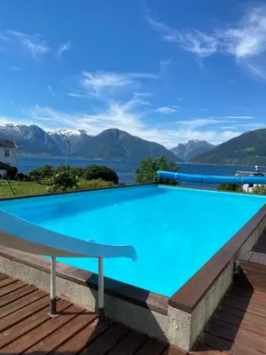 a swimming pool with a view of the mountains at Solvang Ferietun in Vangsnes