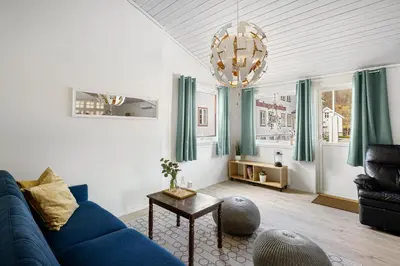 a living room with a blue couch and a chandelier at Hardanger Guesthouse in Ulvik