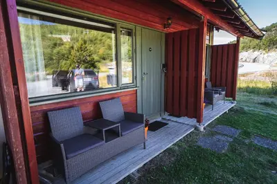 a porch of a house with two chairs on it at Maristova apartment 109 in Filefjell
