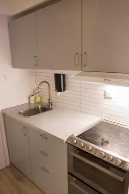 a white kitchen with a sink and a stove at Maristova apartment 109 in Filefjell