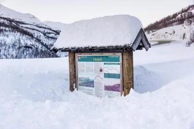 a snow covered sign in the middle of a snow covered field at Maristova apartment 109 in Filefjell
