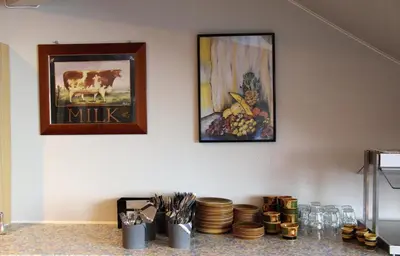 two pictures on a wall with plates on a counter at Akrafjorden Nature B&B AS in Fjæra