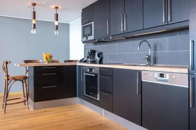 a kitchen with black cabinets and a sink and a counter at Skistar Lodge Trysil in Trysil