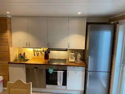 a kitchen with white cabinets and a stainless steel refrigerator at Sunde panorama in Olden