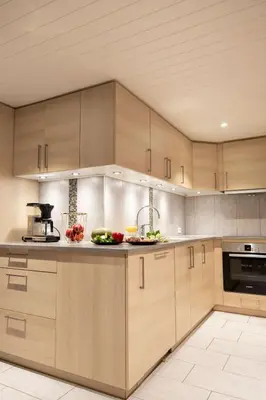 a kitchen with wooden cabinets and fruits on the counter at Vollsnes Feriehus in Hjelle