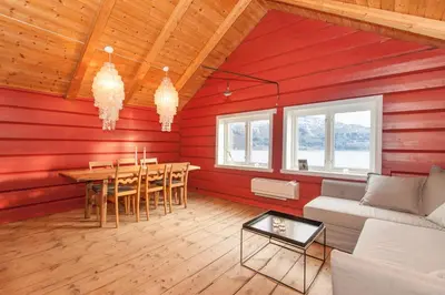 a living room with red walls and a table and chairs at Bodvarstova in Stryn