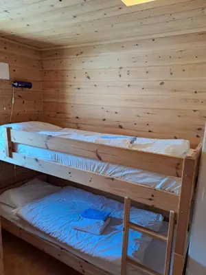 a room with two bunk beds in a wooden wall at Stardalen Hyttegrend in Klakegg