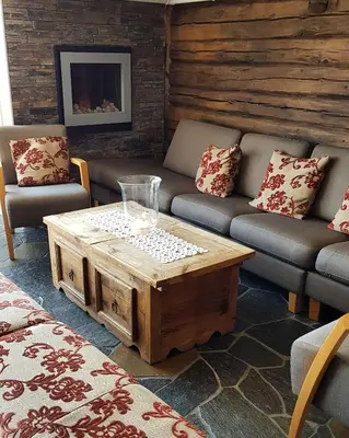 a living room with couches and a coffee table at Erzscheidergaarden Hotell in Røros