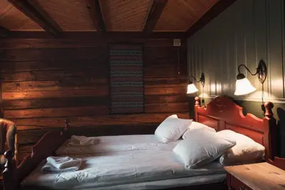 a bedroom with a bed with two lamps on it at Erzscheidergaarden Hotell in Røros