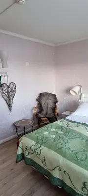 a bedroom with a bed and a table and a heart wall at Erzscheidergaarden Hotell in Røros