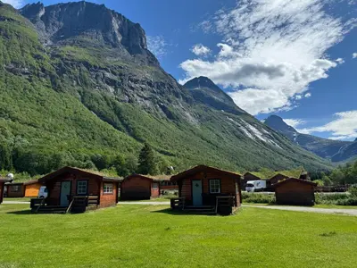 a group of cabins in front of a mountain at Trollstigen Camping and Gjestegård in Åndalsnes