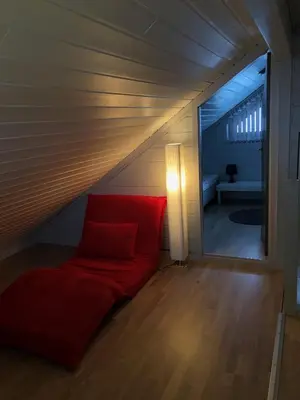 a living room with a red couch in a attic at Voss Hytte/Cabin in Skulestadmo