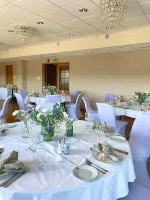 a dining room with white tables and blue chairs at Alver Hotel in Alversund