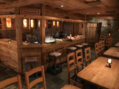 a restaurant with a bar with wooden tables and chairs at Alver Hotel in Alversund