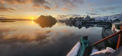 a sunset over a body of water with the sun setting at Hotel Frøya in Sistranda