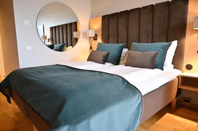 a bedroom with a large bed with a large mirror at Hotel Frøya in Sistranda