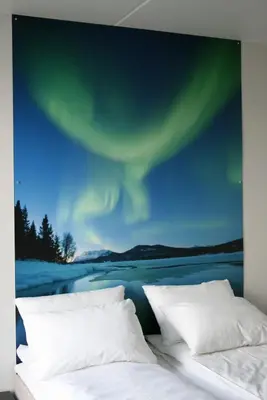 a bedroom with two beds and a painting of the northern lights at P-Hotels Brattøra in Trondheim