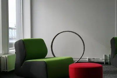 a living room with a green chair and a red stool at P-Hotels Brattøra in Trondheim