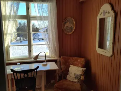 a room with a desk and a chair and a window at Granum Gård in Fluberg