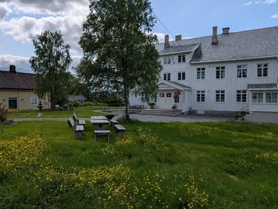 a white house with a picnic table in a field of flowers at Granum Gård in Fluberg