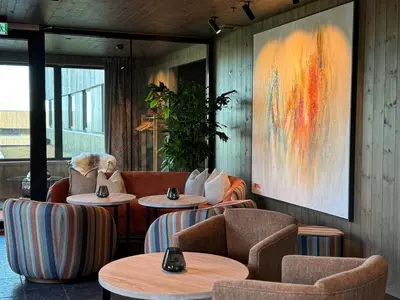 a restaurant with tables and chairs and a painting at Pellestova Hotell Hafjell in Hafjell