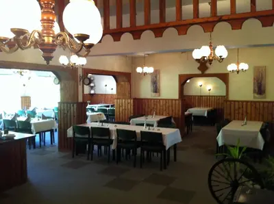 a dining room with tables and chairs and chandeliers at Vossestrand Hotel and Apartments in Myrkdalen