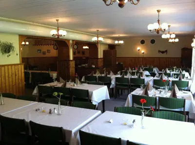 a dining room with white tables and green chairs at Vossestrand Hotel and Apartments in Myrkdalen