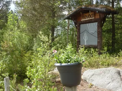 a flower pot in front of a sign in a garden at Gjesteheim Havdal in Sundset
