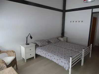 a bedroom with a bed and a lamp and a chair at Gjesteheim Havdal in Sundset