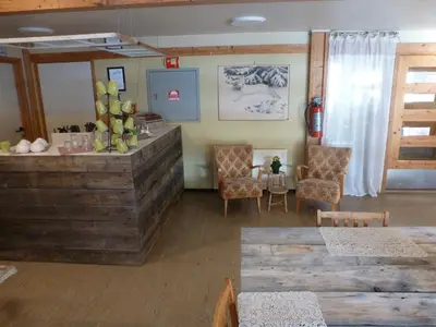 a room with a counter and chairs and a table at Gjesteheim Havdal in Sundset