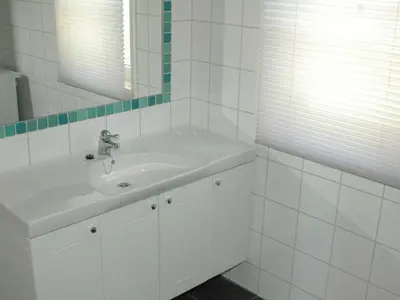 a white bathroom with a sink and a mirror at 6 person holiday home in Åram-By Traum in Sandvik