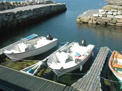 two boats are docked at a dock in the water at 6 person holiday home in Åram-By Traum in Sandvik